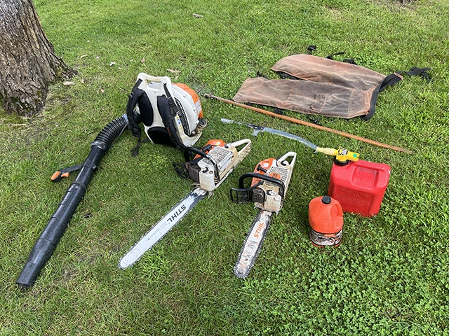 Tree removal tools such as chainsaws, fuel, oil, and a leaf blower.